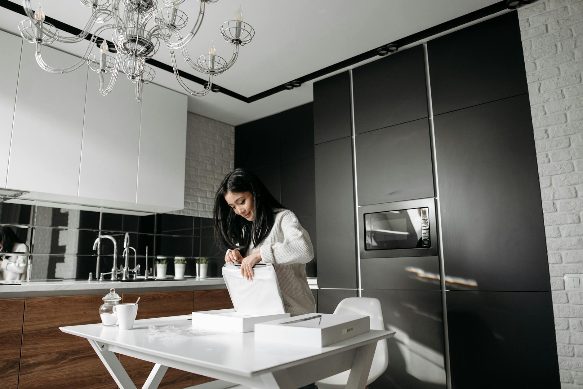 Kobieta rozpakowuje zamówiony sprzęt AGD w nowoczesnej kuchni