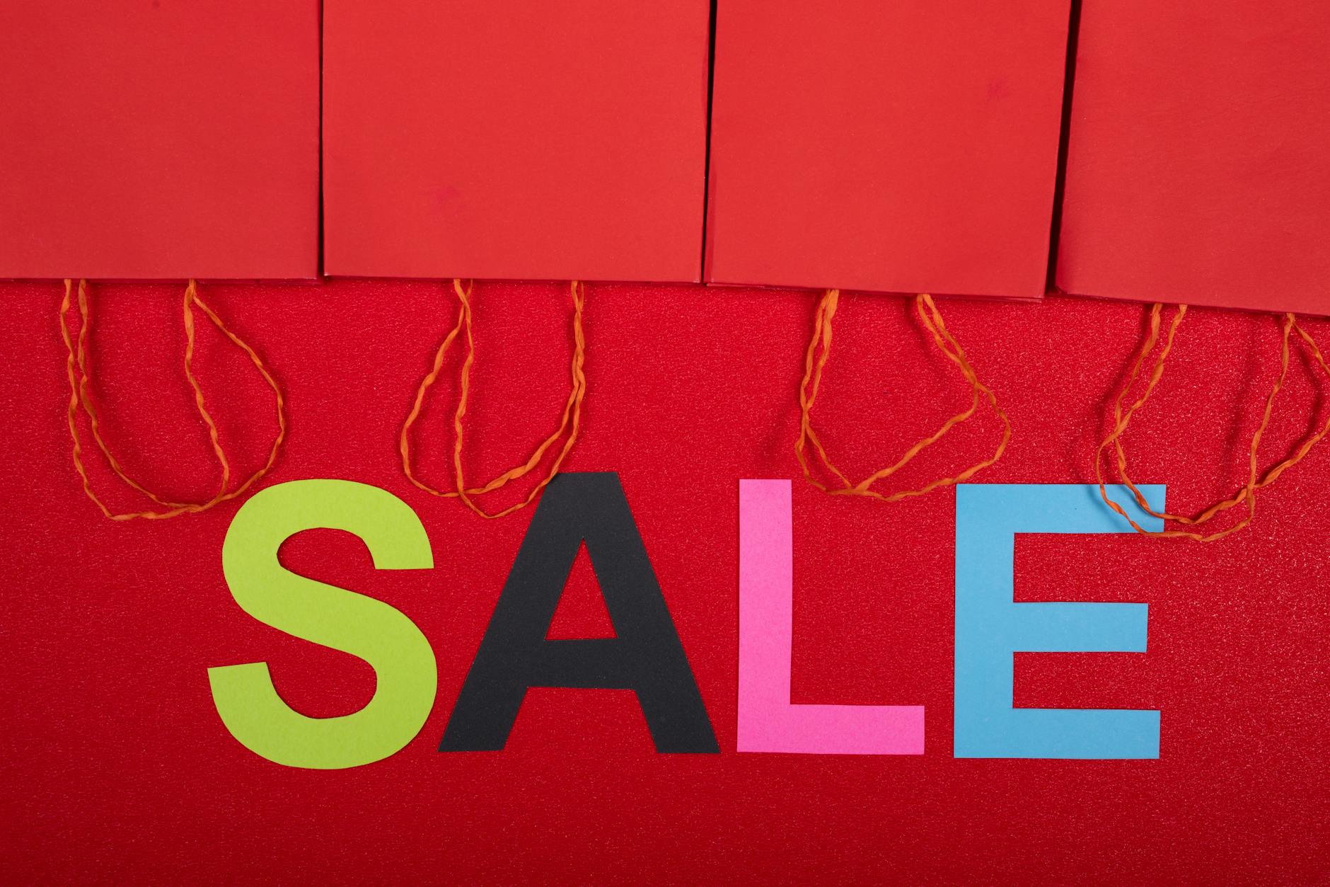 Kolorowy napis sale i czerwone torby zakupowe promujące wyprzedaże