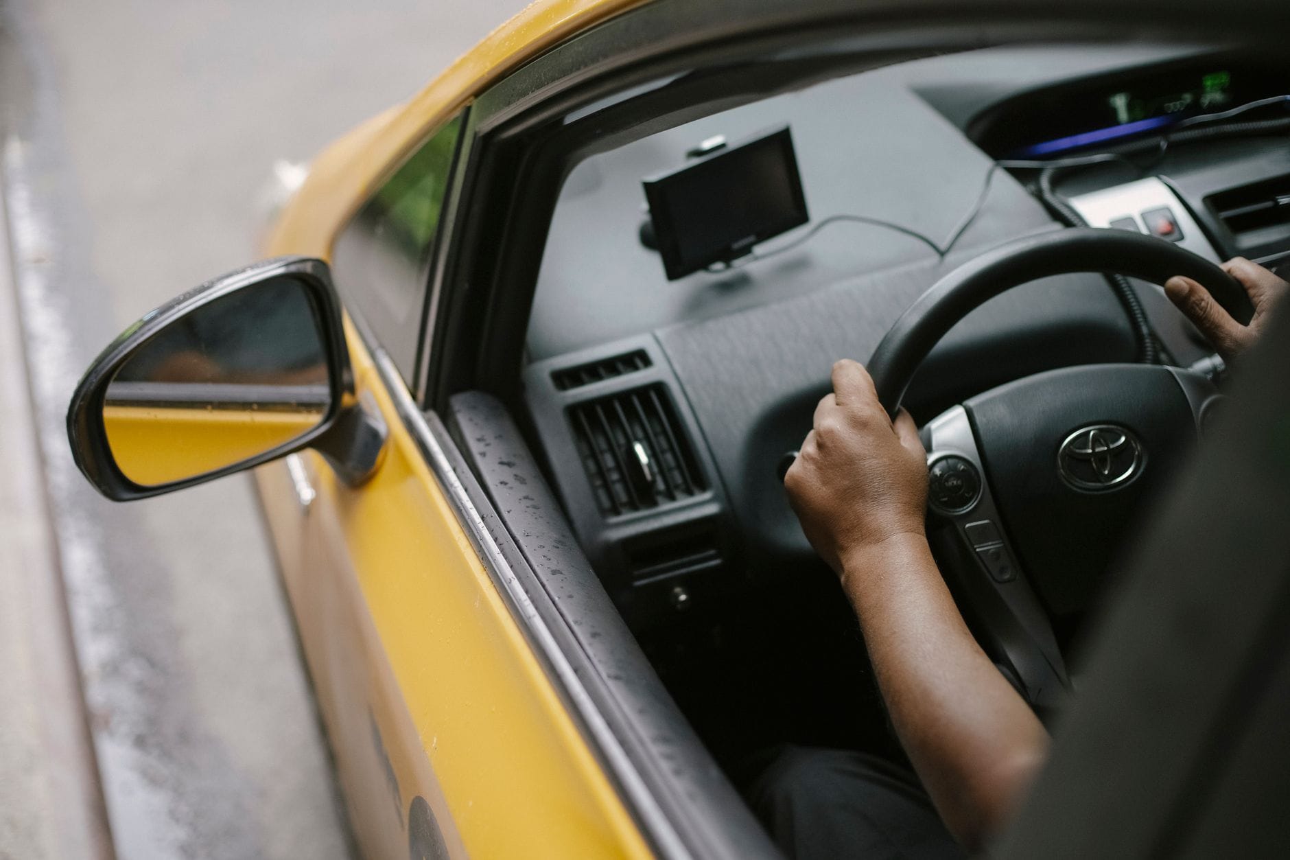 Widok z góry na kierowcę żółtej taksówki z nawigacją GPS w mieście