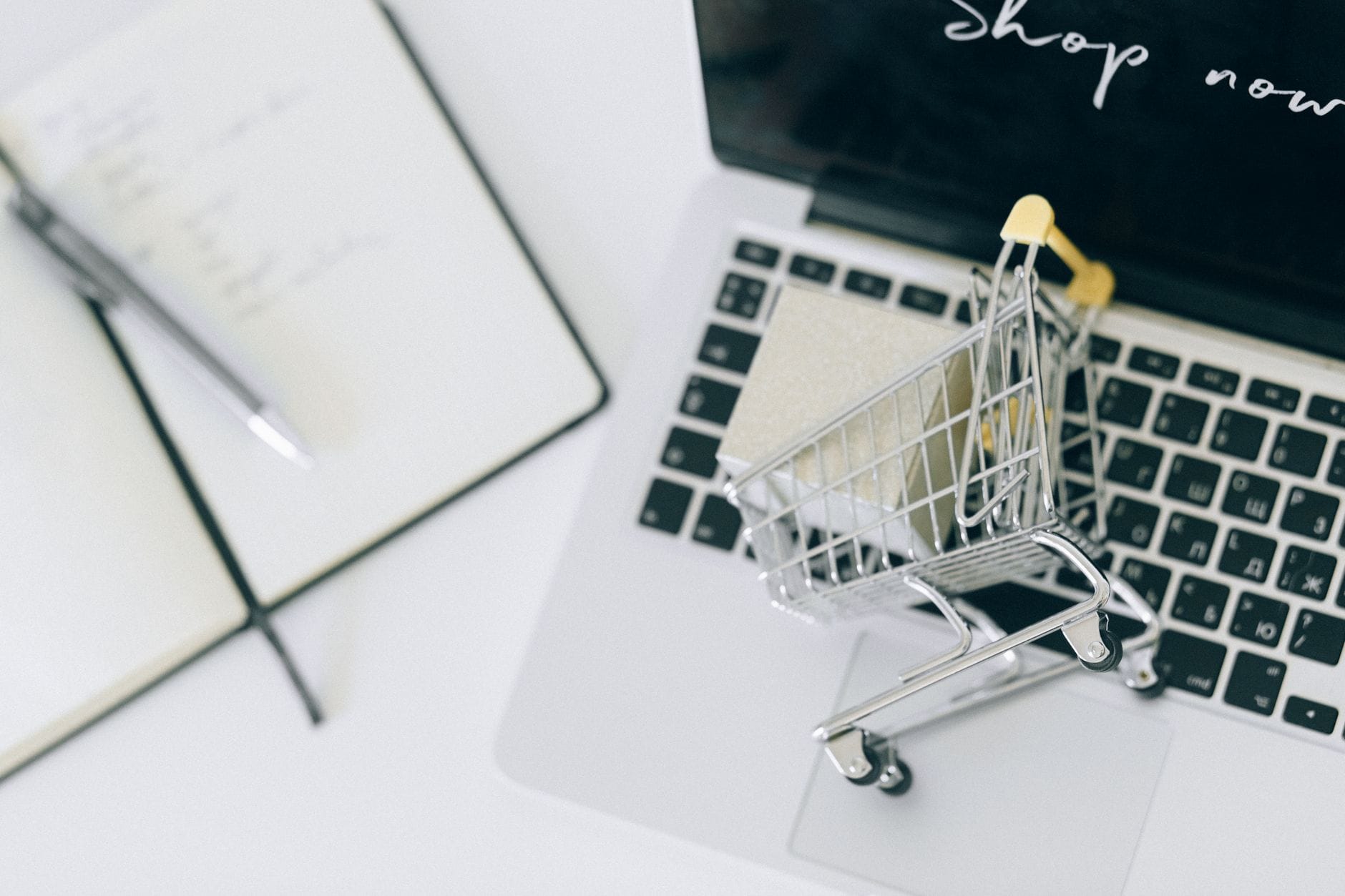Miniaturowy wózek sklepowy na klawiaturze laptopa, zakupy online
